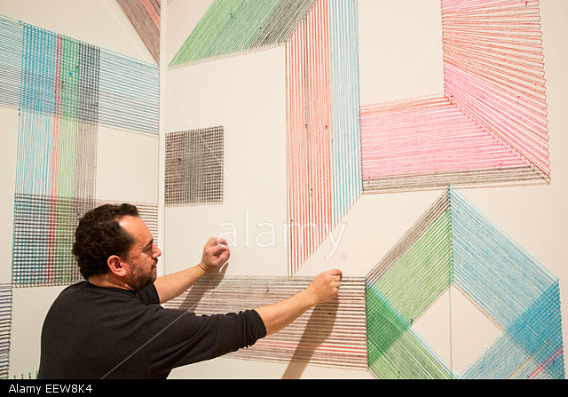 EEW8K4 Leadlight, 2015. Artist Adrian Esparza (USA, 1970) applies the finishing touches to a site-specific work made especially for the exhibition. Esparza uses the traditional blanket often worn as a poncho in this wall-mounted works. The Whitechapel Gallery presents the exhibition Adventures of the Black Square, tracing a century of Abstract art from 1915 to today.